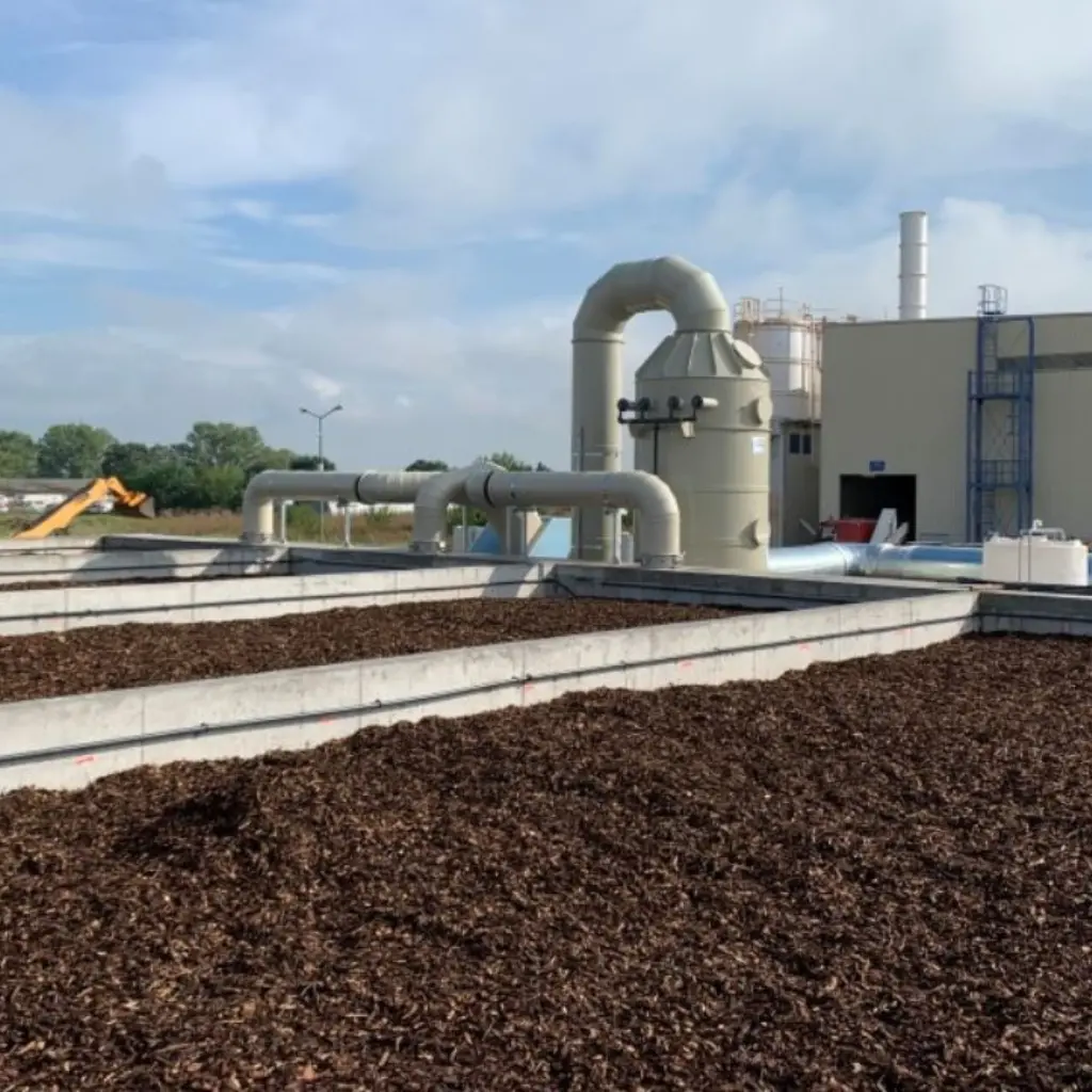 Imagen de un biofiltro industrial con corteza de pino utilizado en el tratamiento de aire, mostrando los sistemas de ventilación y filtración conectados.