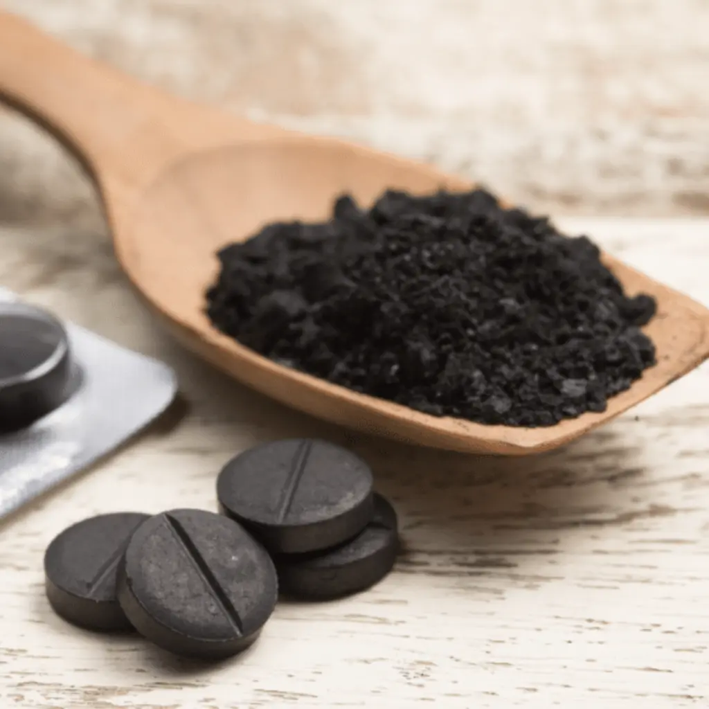 Cuchara con polvo y tabletas comprimidas que ejemplifican visualmente las propiedades del carbon y sus formas de presentación física