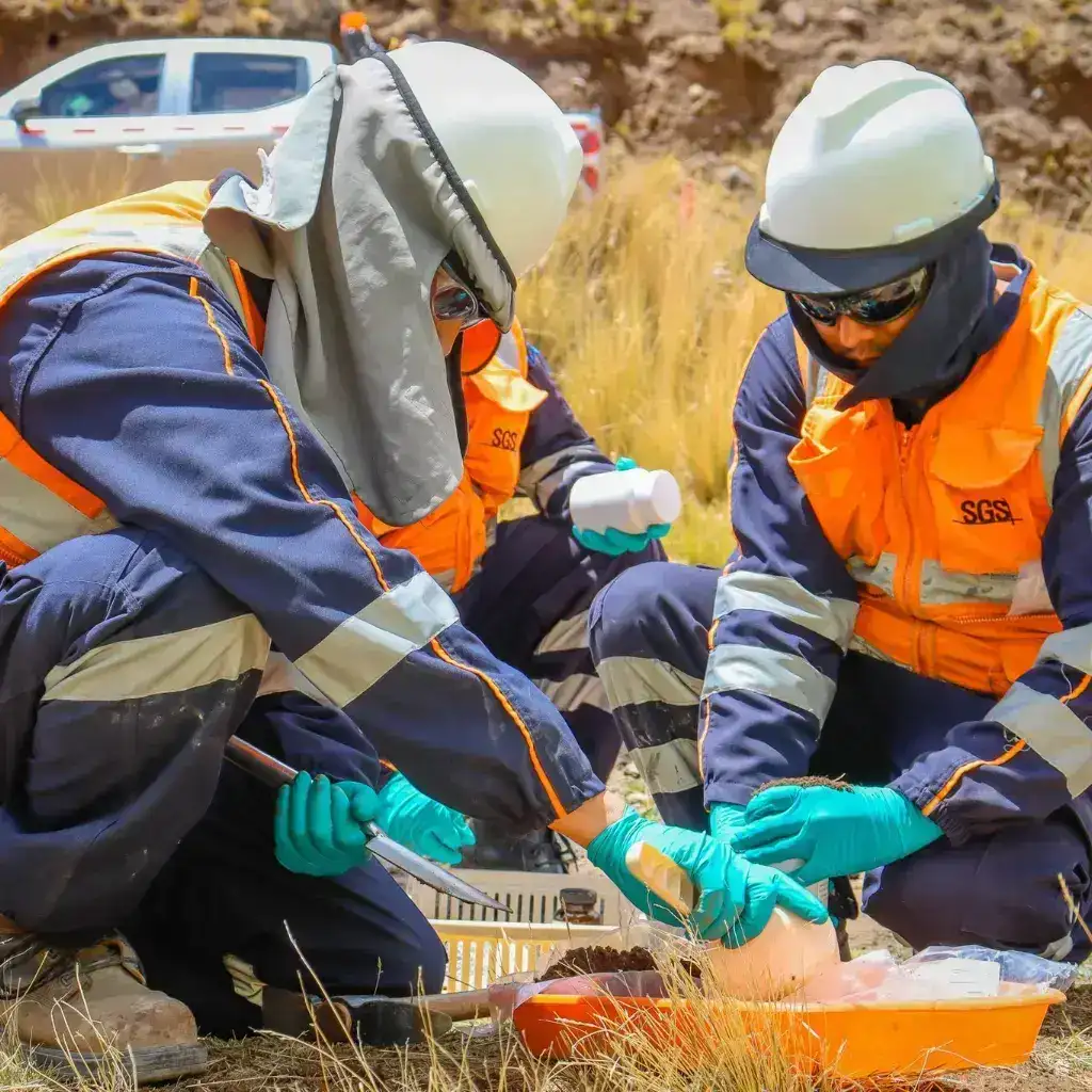 Técnicos realizando toma de muestras de suelo en terreno como parte del monitoreo ambiental para que sirve, utilizando equipos especializados para analizar calidad ambiental.